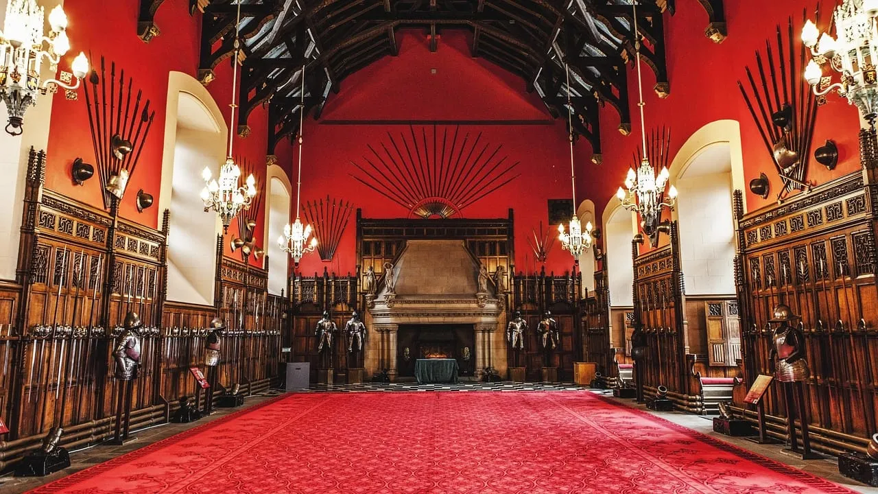 La Great Hall et ses murs rouges, sa charpente en bois et ses panoplies d’armes