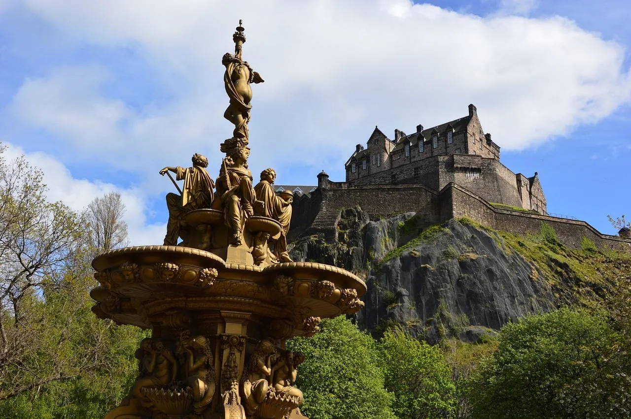 Une fontaine dorée dans un parc au pied du rocher du château