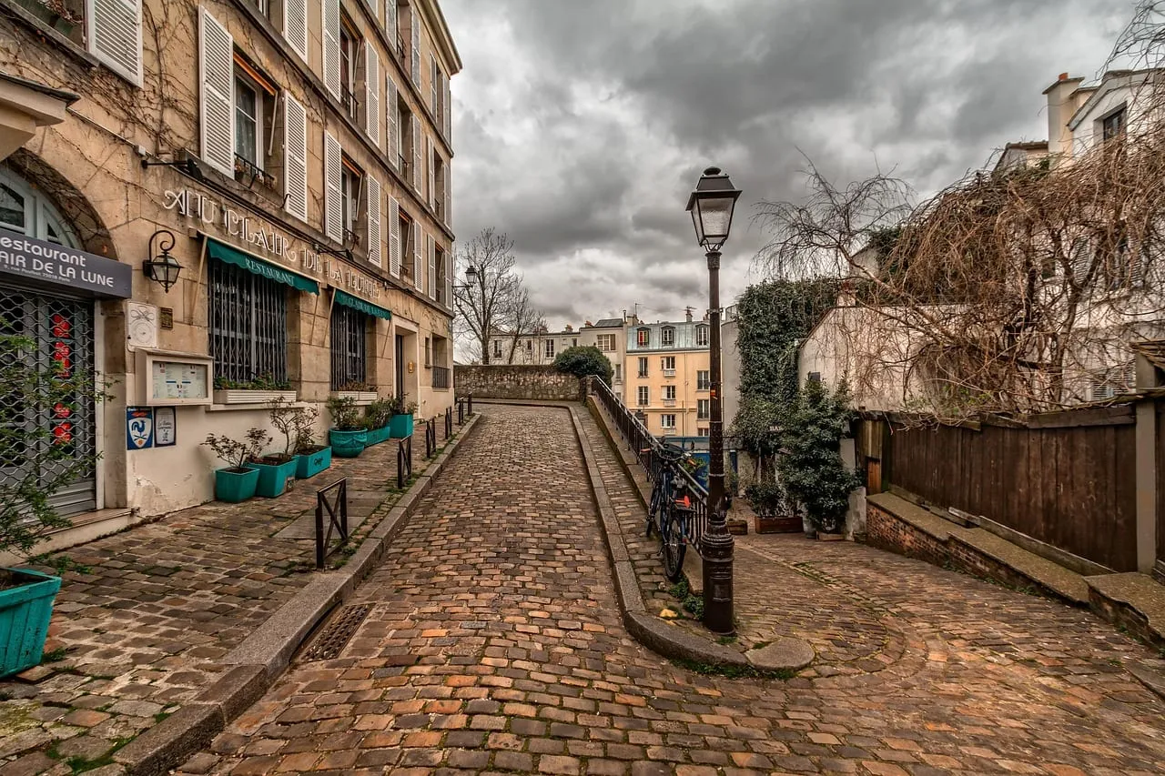 Une ruelle pavée de Montmartre avec ses vieux réverbères et ses maisons
