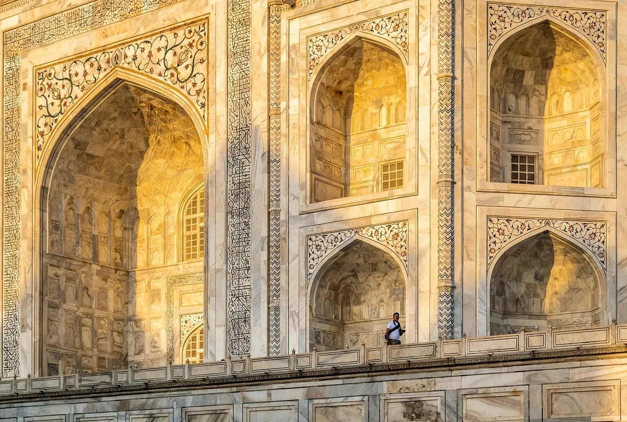 Les arcs de marbre sculptés du Taj Mahal dans une lumière chaude