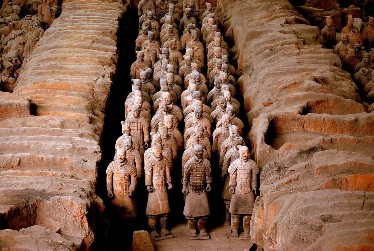 Une longue colonne de guerriers debout entre des murs de terre