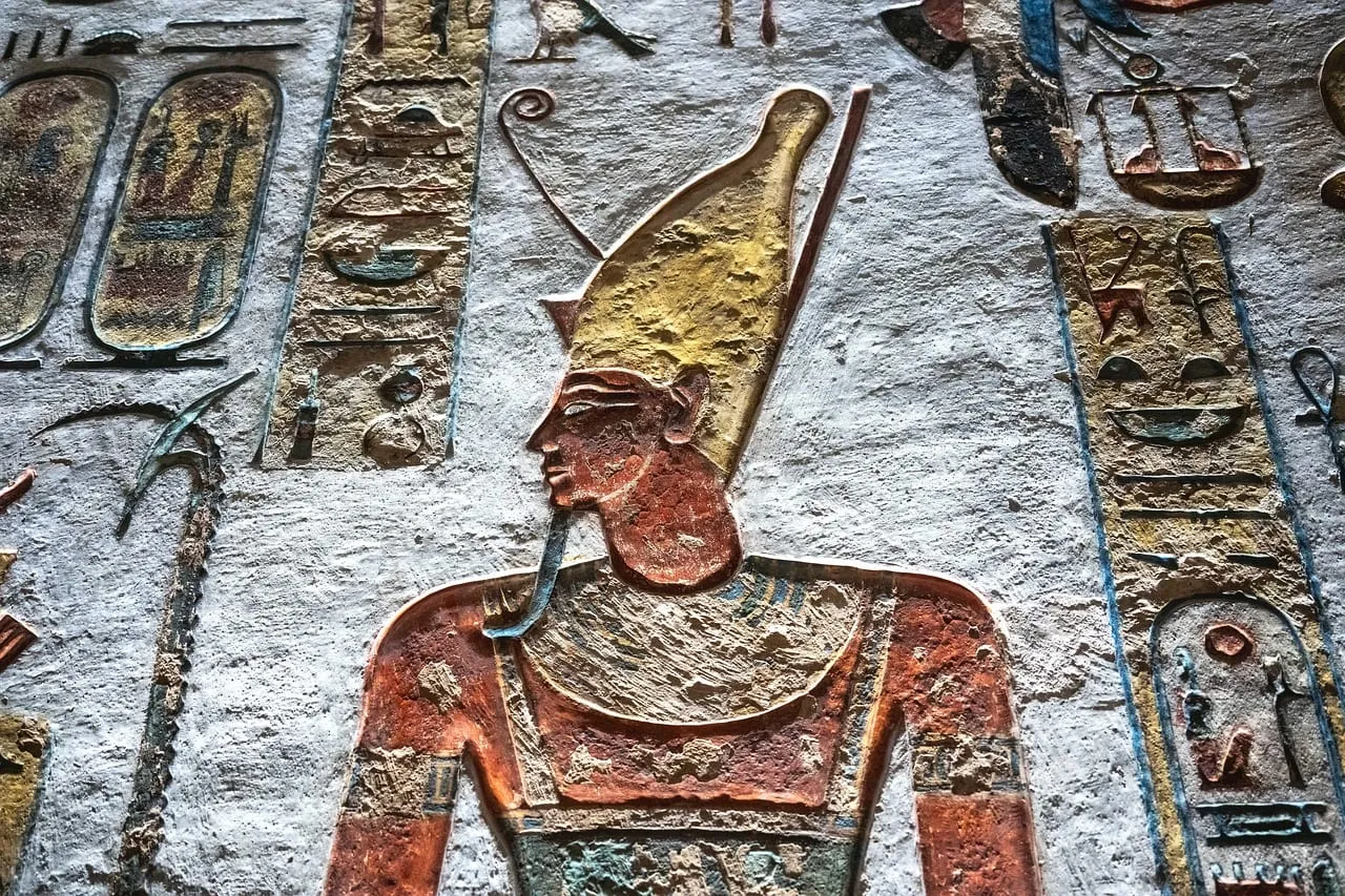 Relief peint d’un roi coiffé d’une haute couronne sur la paroi d’une tombe
